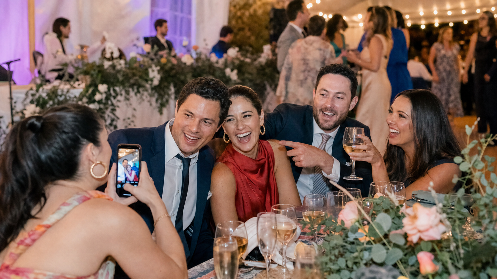Wedding guests laughing and taking candid phone photos